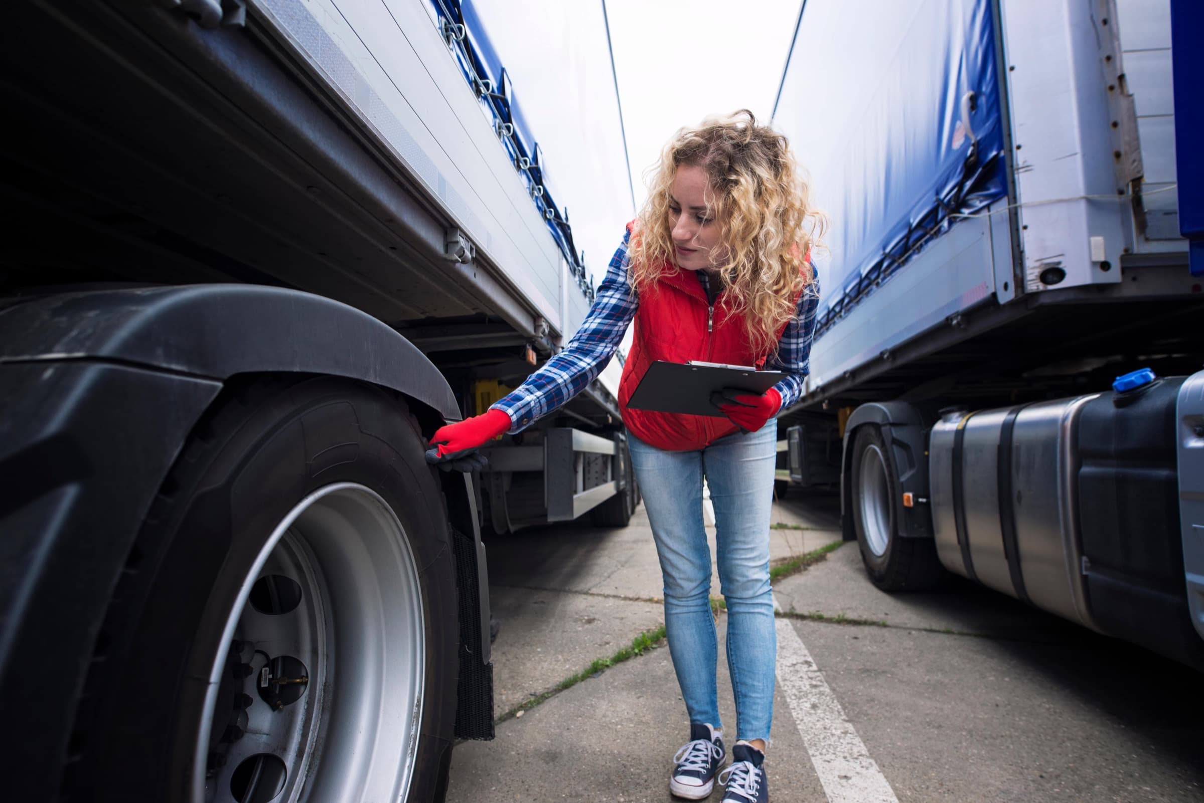 A driver completing a pre-trip inspection while wearing high-visibility safety gear
